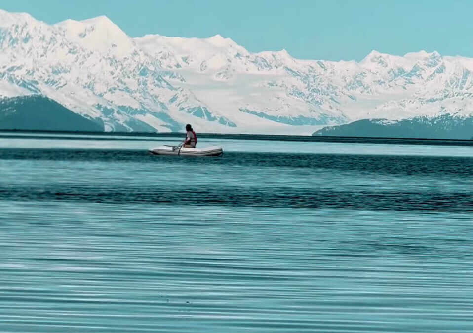 Dinghy rowing in Paulson Bay with College Fjord in the background Prince William Sound, Alaska